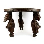 A rare African carved tribal hardwood table/stool with figural legs carved from a single piece of