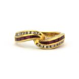 An 18ct yellow gold crossover ring set with baguette cut diamonds and rubies, (L.5).
