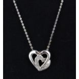 A 9ct white gold diamond set heart pendant and chain, L. 1.2cm.