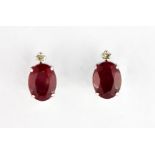 A pair of 18ct white gold stud earrings set with oval cut rubies and diamonds, L. 1cm.