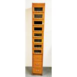 A vintage haberdashery cabinet of glass fronted drawers, W. 33cm H. 210cm.