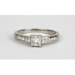 A platinum ring set with a 0.50ct princess cut diamond and brilliant cut diamond set shoulders, (