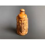 A carved bone snuff bottle in form of the Lucky God Shou Lao. H. 8cms. Condition good.