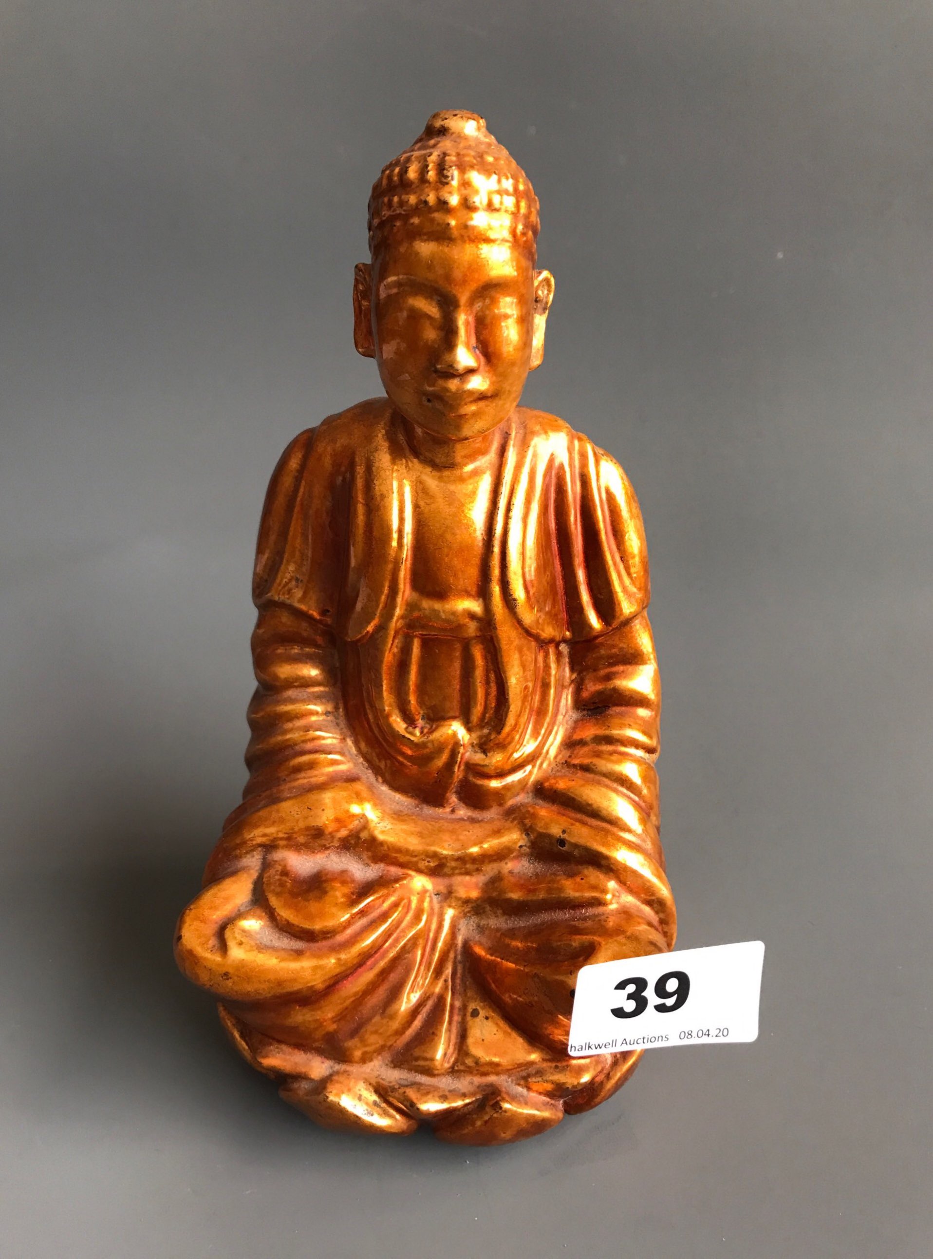 A mid 20thC gilt lacquer finished carved wooden figure of the Buddha seated on a lotus throne. H.