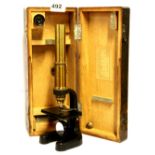 An oak cased Busch early 20th Century brass microscope, H. 27cm.