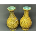 An impressive pair of Chinese relief decorated vases with Imperial Yellow glaze featuring eight