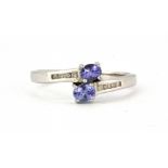 A 9ct white gold tanzanite and diamond set crossover ring, (P).