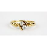 An 18ct yellow gold diamond set crossover ring, (M).