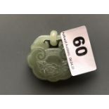 A carved green nephrite jade lock amulet with integral ring and decorated with a flower, usually