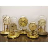 Five vintage torsion pendulum clocks, one battery operated but without pendulum, two glass domes,