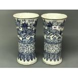 A pair of cylinder shaped Chinese porcelain vases with flared neck, hand painted in underglaze