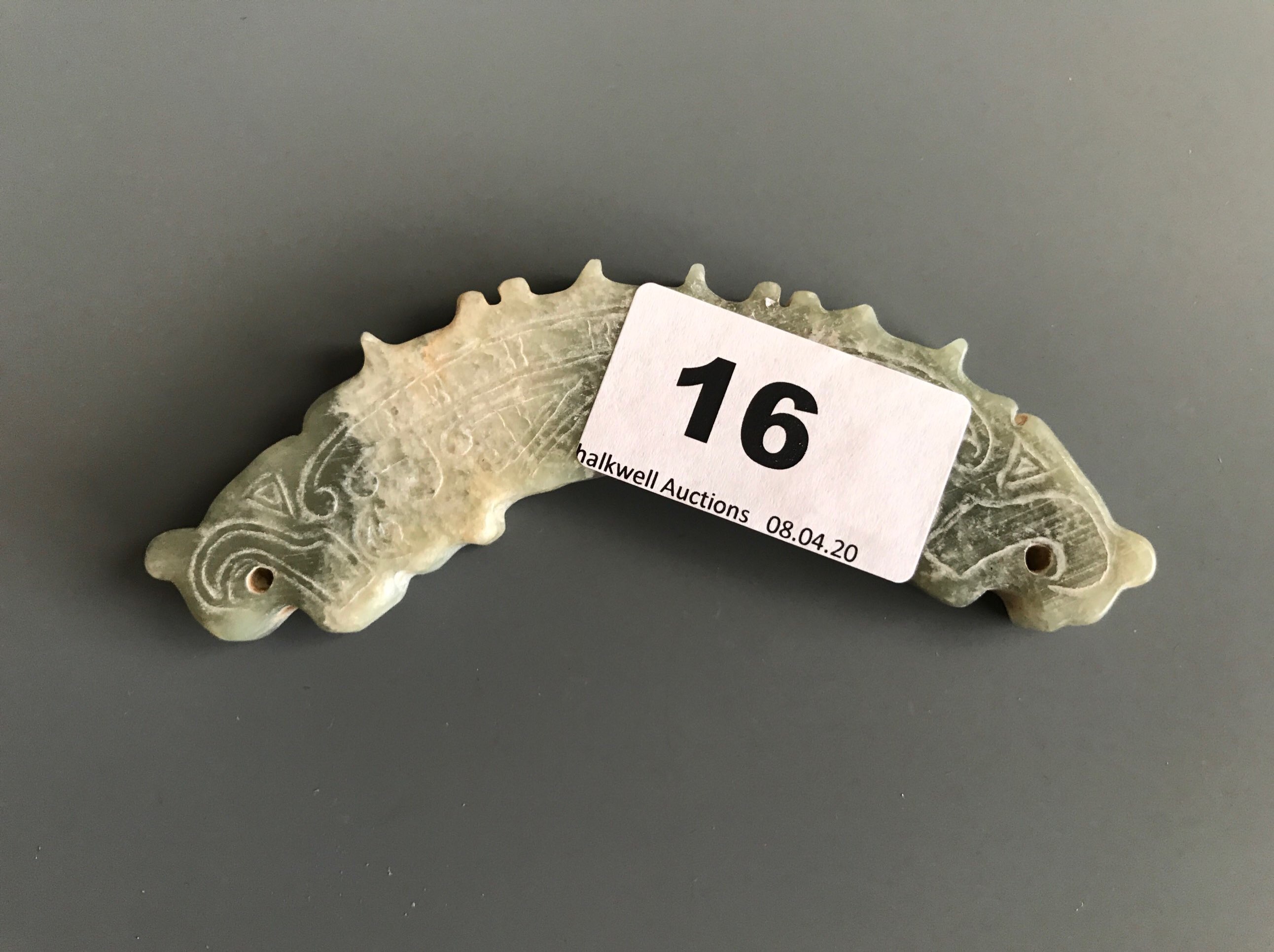 A Chinese archaic form carved mixed colour nephrite jade amulet. W. 11cms. Condition good with no