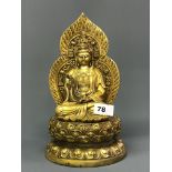 A Sino-Tibetan gilt bronze figure of the seated goddess Guanyin with flame background embellished