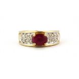 A 9ct yellow gold ring set with an oval cut ruby and diamonds, (L).