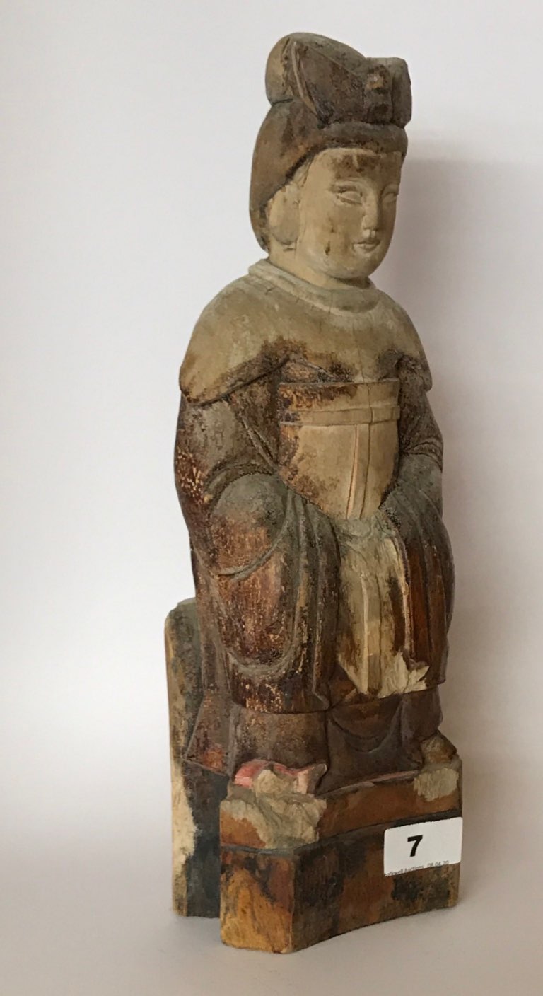 An early 20thC Chinese carved wooden ancestor figure of a woman with bound feet wearing robes and