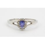 A 9ct white gold cluster ring set with a pear cut tanzanite surrounded by diamonds, (O).