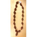 A strand of nineteen carved nut prayer beads each decorated with an image of Putai, bead H. 3.5cm.