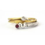 An 18ct yellow and white gold diamond and ruby set crossover ring, (N).