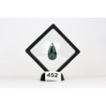 A large pear cut natural emerald on a display stand, approx. 56.82ct.