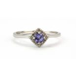 A 9ct white gold ring set with a round tanzanite surrounded by diamonds, (P.5).