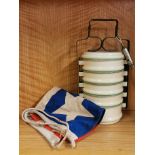 A set of vintage stacking enamelled food containers, a military whistle and a vintage flag.