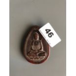 A Sino-Tibetan carved yak horn amulet of the seated Buddha. H. 6.5cms. Condition good but with