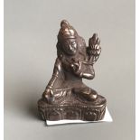 A small Tibetan bronze figure of a seated deity. H. 6cms. Condition good with slight rubbing to