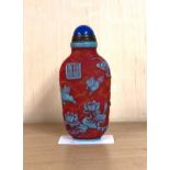 A Chinese signed three layer carved Peking cameo glass snuff bottle decorated with birds and lotus