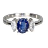 A 925 silver ring set with an oval cut sapphire and white stones, (S).