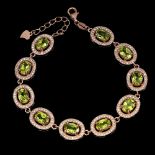 A 925 silver rose gold gilt bracelet set with oval cut peridots and white stones, L. 19cm.