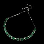 A 925 silver adjustable bracelet set with oval cut emeralds.