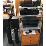 An ARCAM CD player, tuner and amplifier with a pair of RUARK speakers on heavy metal stands