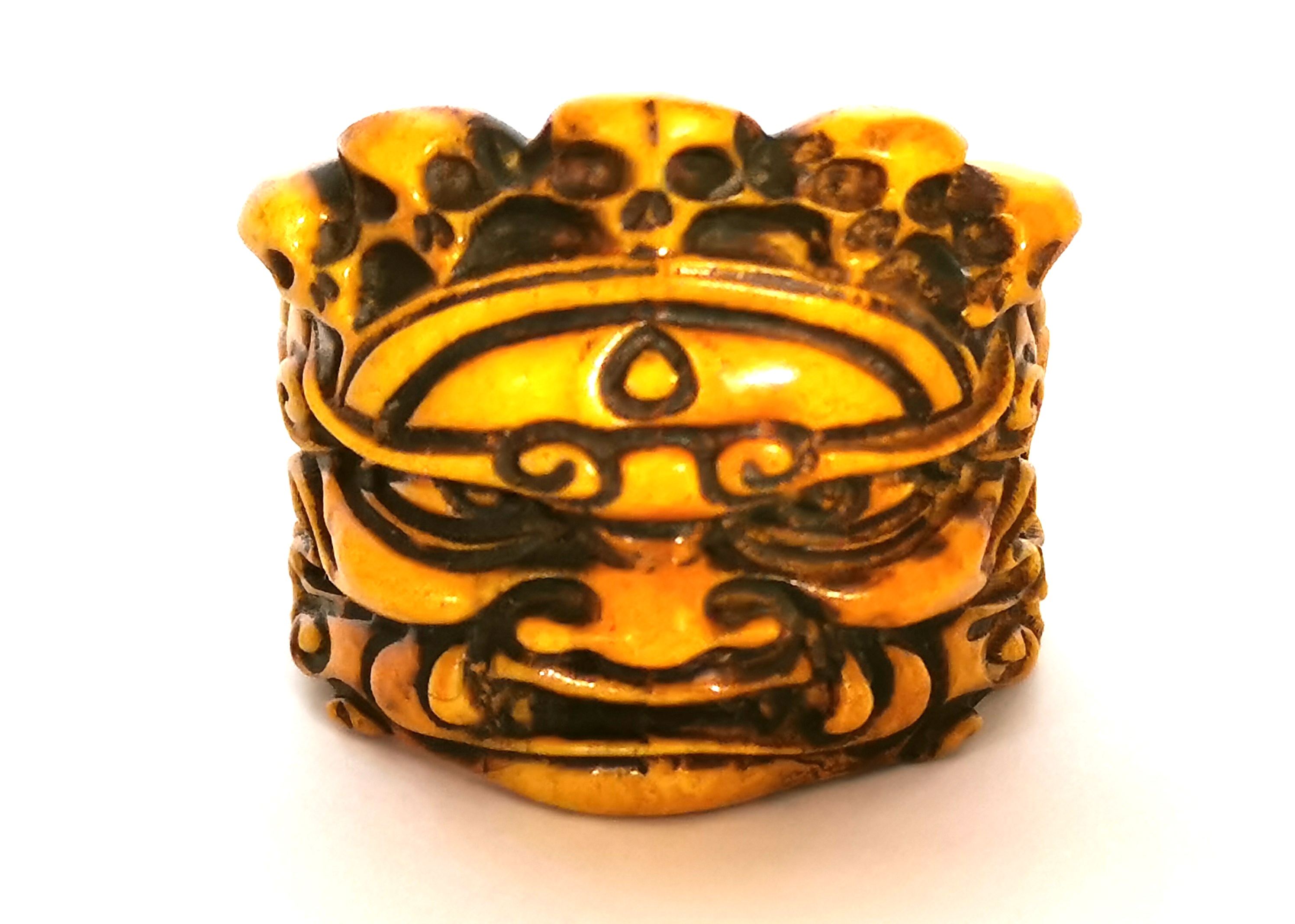 A Tibetan carved bone man's ring of a guardian deity wearing a skull crown, H. 2.5cm internal Dia.