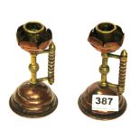 A pair of Christopher dresser hammered copper brass and wood candlesticks, H. 13cm.