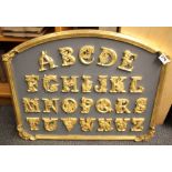 A gilt and painted plaster alphabet panel, size 63 x 50cm.