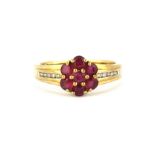 A 9ct yellow gold ruby set cluster ring with diamond set shoulders, (N).