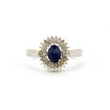A 925 silver ring set with an oval cut sapphire and white stones, (S).