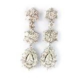 A pair of white metal (tested 18ct gold) drop earrings set with pear and brilliant cut diamonds,
