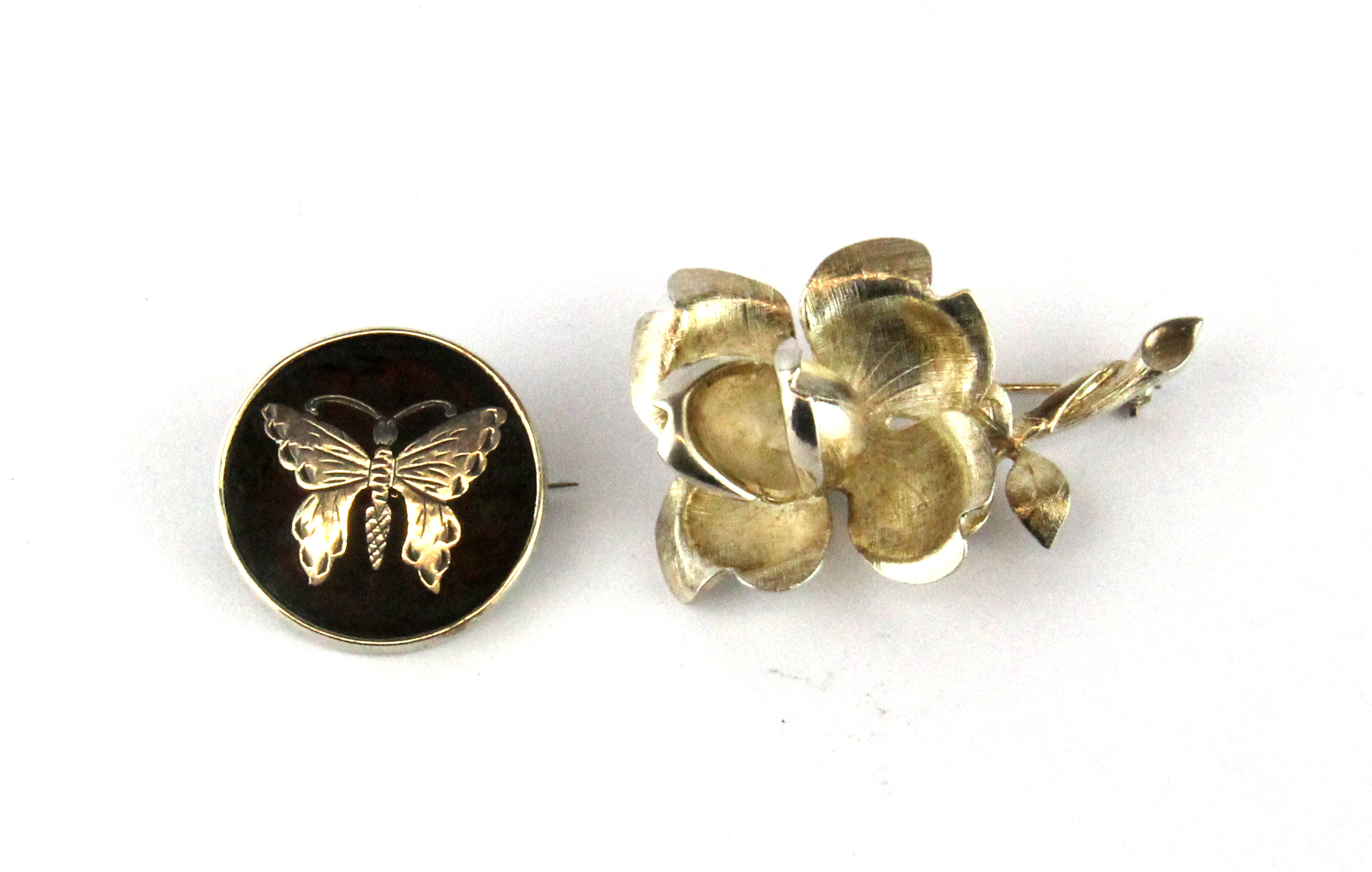 A silver pique butterfly brooch and silver rose brooch.