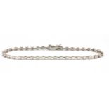 An 18ct white gold (stamped 18k) diamond set line bracelet, approx. 2ct overall, L. 18cm.
