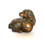 A finely carved fruitwood netsuke with a dog and a ball, with black onyx eyes, H. 4cm. Condition:
