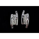 A pair of 18ct white gold stud earrings set with three brilliant cut diamonds, L. 1.2cm.