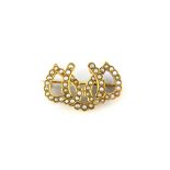A yellow metal (tested minimum 9ct gold) brooch set with split pearls, L. 2.6cm.
