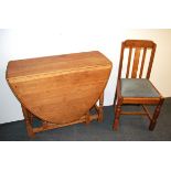 A golden oak drop leaf dining table, W. 92cm, together with an oak chair.