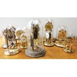 A group of thirteen torsion pendulum mantle clocks mainly under glass domes, tallest 30cm.