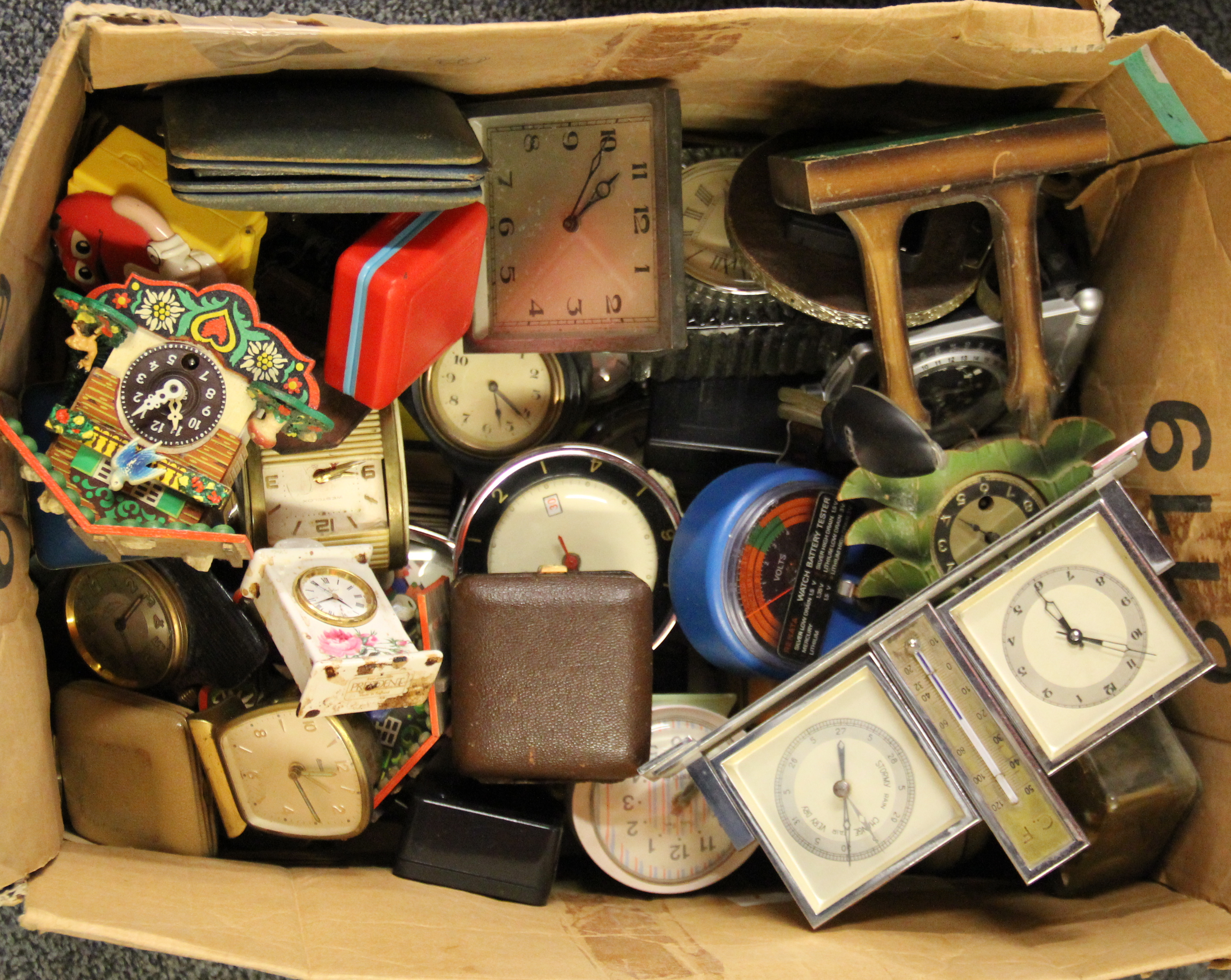 A box of small mixed vintage clocks.