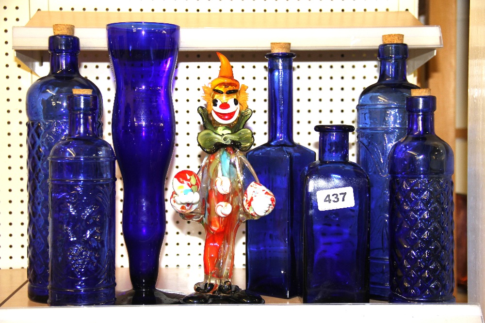 A Murano glass clown, H. 27cm, a glass vase and collection of glass bottles.