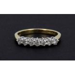 An 18ct yellow and white gold half eternity ring set with brilliant cut diamonds, (L).