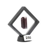 An unmounted step cut ruby in a perspex display stand, approx. 251.25ct.