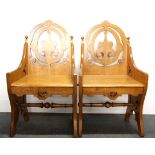 A pair of ecclesiastical carved oak chairs, H. 93cm.